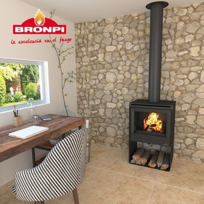 Lareira a lenha preta com vidro frontal e fogo, parede de pedra, cadeira riscada, mesa de madeira junto a janela