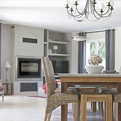 Sala de jantar e estar com mesa de madeira e cadeiras rattan