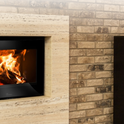 Lareira moderna embutida numa parede de pedra com fogo aceso próximo de colunas de som e equipamento de áudio