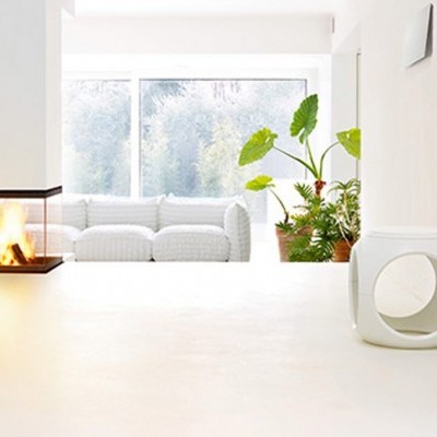 Sala moderna com lareira de vidro, sofá branco, plantas e mesa branca quadrada.