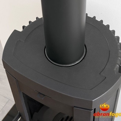 Estufa a lenha preta com tubo de fumo em fundo de madeira clara