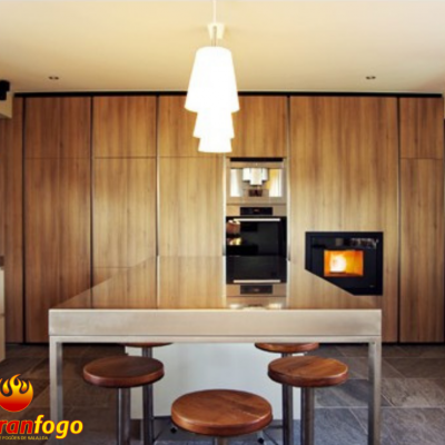 Cozinha moderna com armários de madeira clara, forno embutido e mesa de vidro