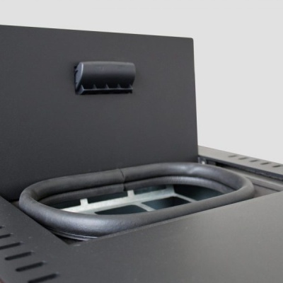 Aparelho metálico preto com tampa superior aberta e puxador acolchoado.