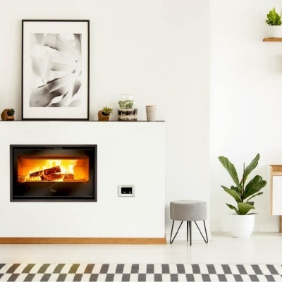 Lareira embutida numa parede branca com decoração moderna e plantas