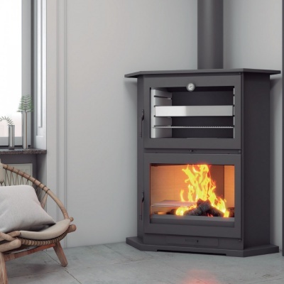 Lareira a lenha preta com forno e fogo visível, junto a cadeira de vime e janela