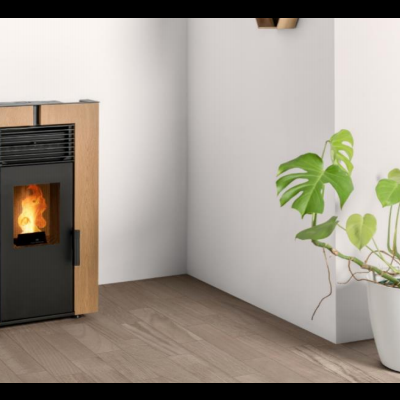 Lareira a pellets em madeira clara com planta verde em vaso branco ao lado