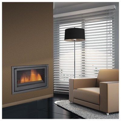 Poltrona bege junto a lareira embutida e candeeiro de pé com cúpula preta num ambiente moderno