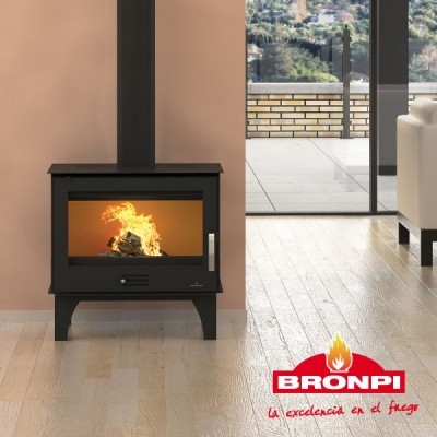 Lareira a lenha preta acesa numa sala com chão de madeira clara e varanda ao fundo