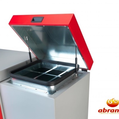 Equipamento metálico industrial com tampa vermelha aberta e quatro divisórias internas pretas