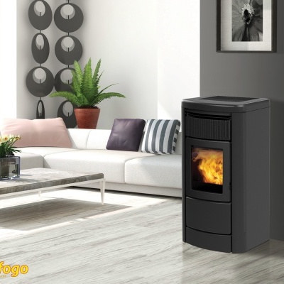 Salamandra a lenha preta com chama visível numa sala moderna com sofá branco