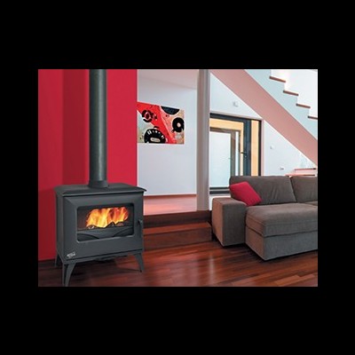 Lareira a lenha preta junto a parede vermelha num espaço com sofá e escada