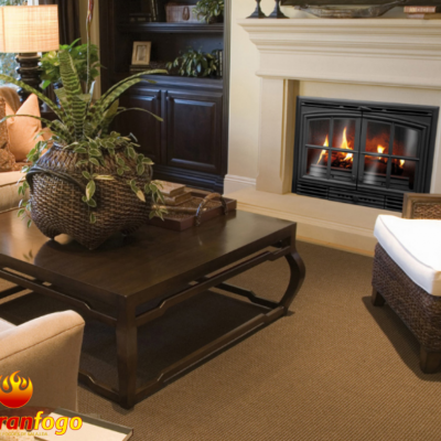 Sala de estar com lareira em ferro, mesa de centro em madeira escura, sofá e cadeiras em tecido bege com almofadas laranja.