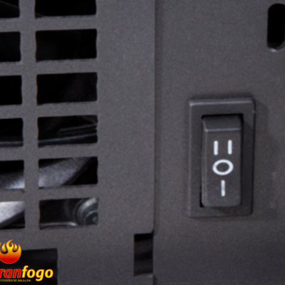 Interruptor preto com três posições numa estrutura metálica preta com grelha ao lado e logo abranfogo