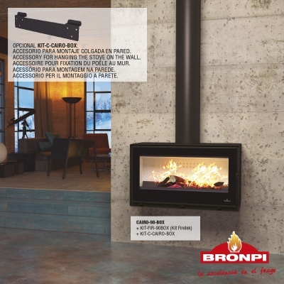 Lareira a lenha preta com vidro frontal e fogo, parede de betão cinzento, chão de cimento polido.