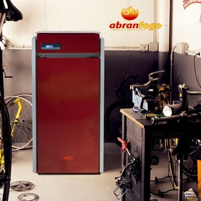 Caldeira vermelha de aquecimento central com visor digital em espaço com ferramentas e bicicletas