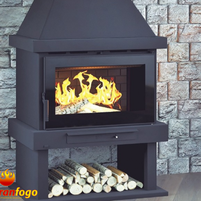 Lareira preta com fogo aceso e troncos armazenados, parede de pedra ao fundo