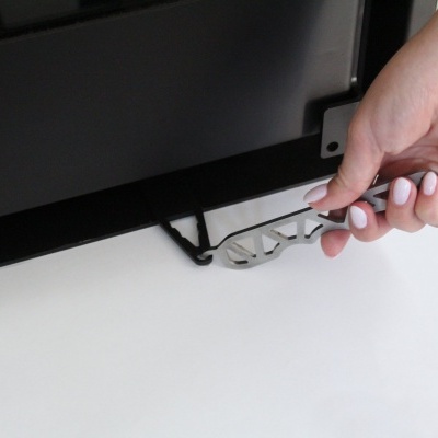 Chave metálica prateada a ser inserida numa estrutura preta sob aparelho