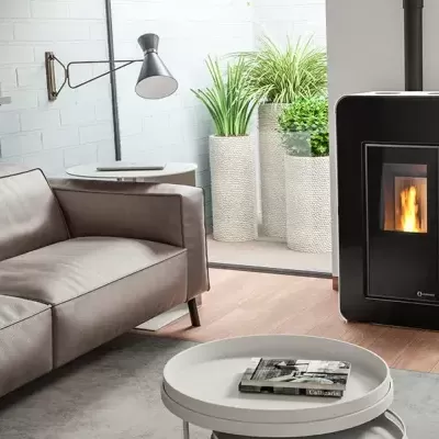 Sala moderna com sofá de couro castanho, lareira preta a pellets e plantas em vasos cinzentos