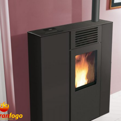 Salamandra preta com fogo visível e tubo de evacuação junto a parede cor de rosa