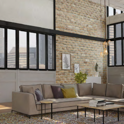 Sala com sofá cinzento, lareira suspensa preta e paredes com tijolos aparente