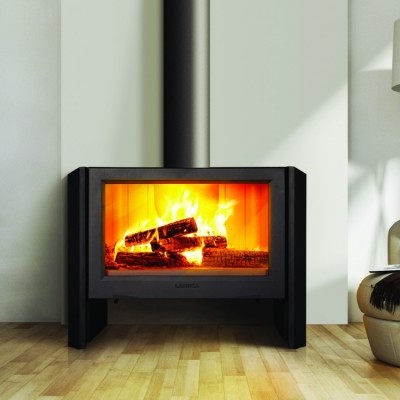 Lareira moderna preta acesa numa sala com poltrona branca e escada flutuante preta