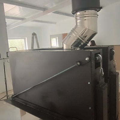 Estufa de fogão a lenha em metal preto com tubo de escape prateado e vidro frontal