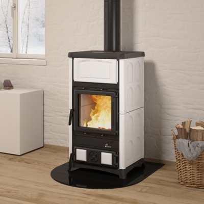 Lareira a lenha preta e branca com vidro mostrando fogo, em chão de madeira e parede branca