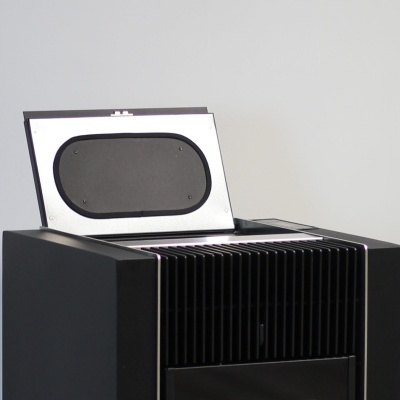 Aparelho eletrónico preto com tampa aberta mostrando superfície oval negra