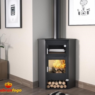 Lareira preta com forno e chaminé junto à parede, madeira armazenada na base