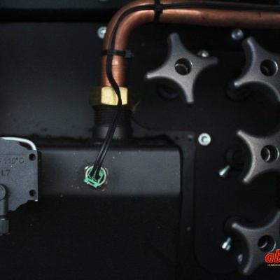 Equipamentos e tubos de cobre com válvulas pretas e texto num componente preto