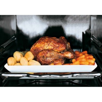 Prato branco com frango assado, batatinhas pequenas e cenouras dentro de um forno