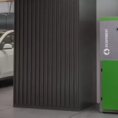 Carro elétrico branco numa garagem com estação de carregamento EnergyNest verde e cinza