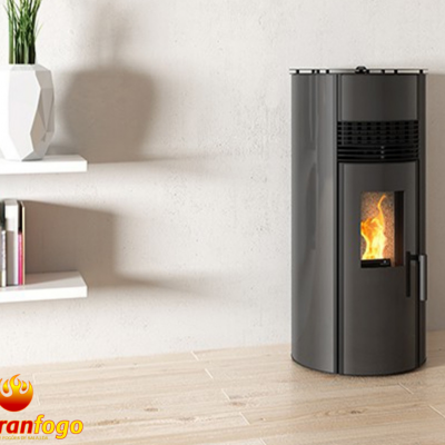 Lareira a pellet cilíndrica cinza com chama visível junto a estante e planta