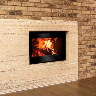 Lareira embutida com porta de vidro preto numa parede de pedra e tijolos.