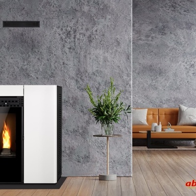 Lareira a pellet branca com chama visível, parede cinzenta, chão em madeira e sofá castanho