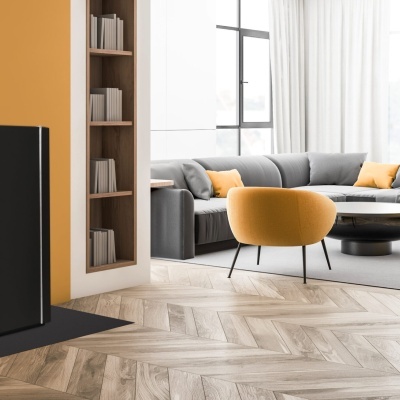 Sala de estar com lareira a pellet preta, sofá cinzento e poltrona amarela