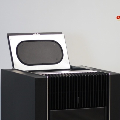 Aquecedor ou salamandra preta com tampa aberta e fundo cinza claro