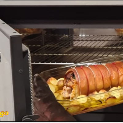 Assado com batatas dentro de forno preto aberto