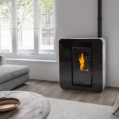 Sala de estar com sofá cinzento, lareira preta acesa e mesa redonda de madeira