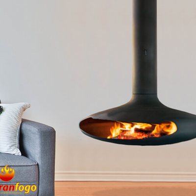 Lareira suspensa preta acesa junto a sofá cinza com almofadas