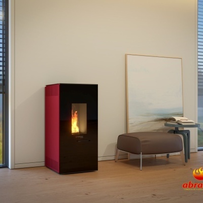 Estufa a pellets preta e vermelha acesa numa sala minimalista com chão de madeira clara