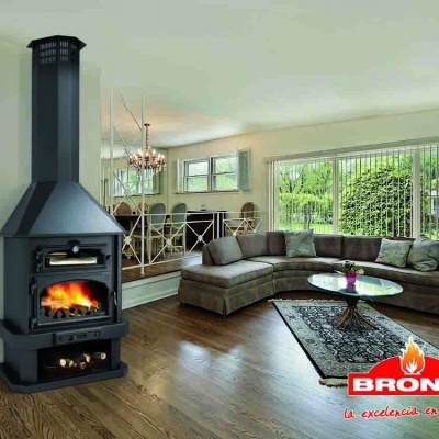 Sala de estar com lareira BRONPI acesa, sofá cinzento e mesa de centro de vidro