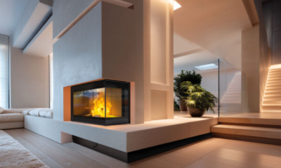 Lareira moderna em canto com vidro e fogo, em sala com piso de madeira clara e sofá branco