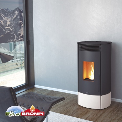 Câmara de aquecimento a pellets preta e branca ligada, numa sala com chão em madeira e vista de montanhas nevadas