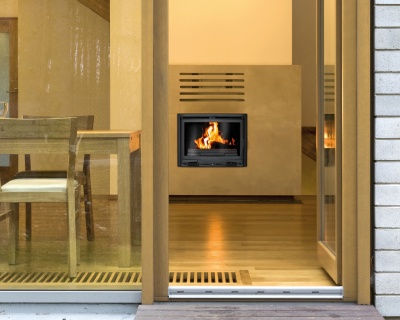 Lareira embutida numa parede bege numa sala com parquet e móveis de madeira