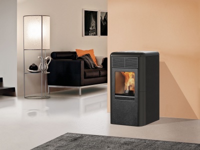 Lareira a pellets preta numa sala moderna com sofá e candeeiro