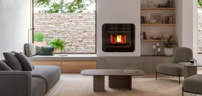 Sala de estar com lareira moderna, sofá, cadeira e mesa de centro, com janelas grandes e parede de pedra exterior