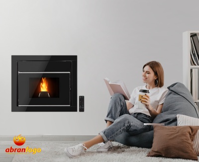 Salamandra embutida preta com fogo, mulher sentada no chão a ler e beber, sofá e tapete cinzento