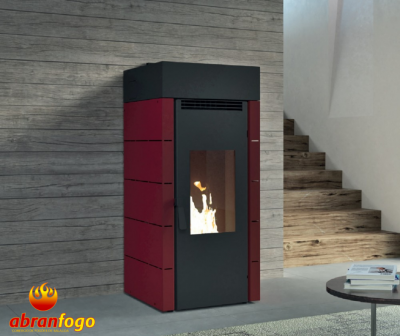 Estufa a pellets vermelha e preta com chama visível e ambiente interior com parede de madeira e escada
