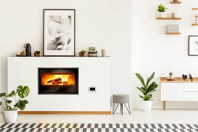 Lareira embutida numa parede branca com decoração moderna e plantas